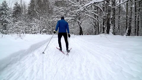 Back view young professional athlete works out and does cross country skiing Video stock 244594947