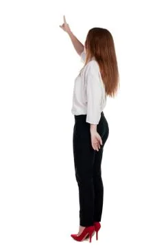 Back view of young redhead business woman pointing at wal 스톡 사진