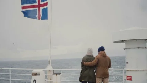 Back view of young stylish couple standing on the board of the ship with Video stock 82998910