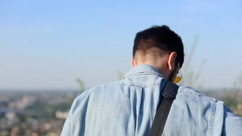 Back view of young stylish man in sunglasses standing outside on sunny backgroun 스톡 동영상 131289857