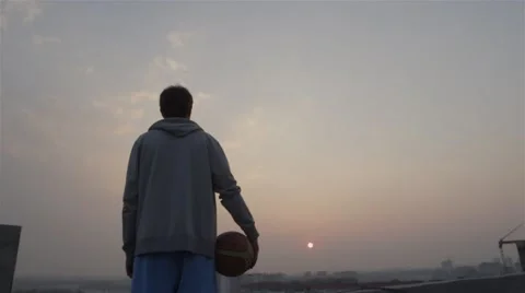 Back view of a young successful basketball player standing on the roof. 4k Stock Footage 49615653