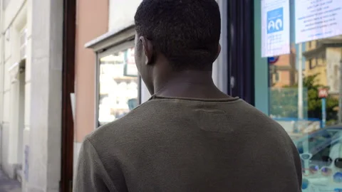 Back view of young unemployed black man walking alone on the street Vídeos de archivo 133415980