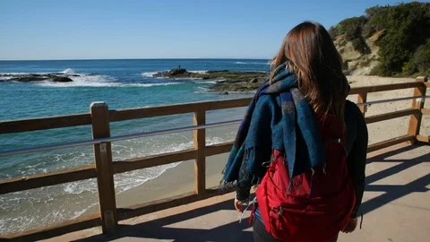 Back view of young woman with backpack and scarf getting closer to the fence on Video stock 102171032