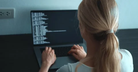 Back view young woman computer programmer looking at computer monitor and Stock Footage 244069192