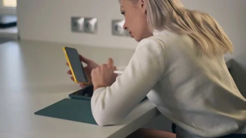 .Back view of young woman using mobile phone and digital tablet for lesson on Stock-Footage 143009723