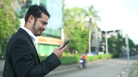 Back view.Businessman walking using a smartphone in urban Stock Footage 174611003