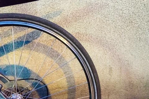 Back wheel of a bicycle in the night in front of a wall Stock Photos
