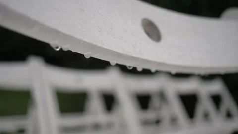 The back of a white wedding chair with raindrops. Good luck: rain at the wedding Stock Footage 140734366