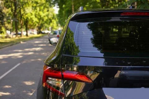 Back window of black car parked on the street in summer sunny day, rear view. Foto stock