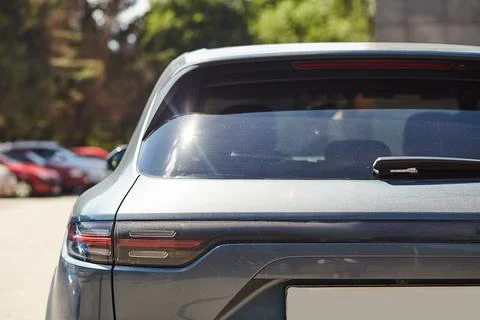 Back window of black car parked on the street in summer sunny day, rear vie.. Stock Photos