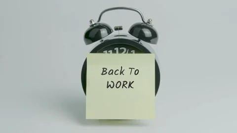 Back To Work Text or Word on Yellow Note Paper Sticking onto Black Clock Stock Footage 299977656
