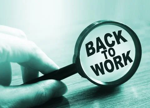 Back to work is written under magnifier in hand. Business concept Фото