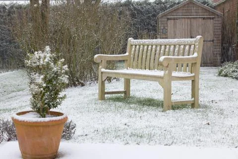 Back yard backyard with garden bench in snow. UK winter gardens Stock Photos