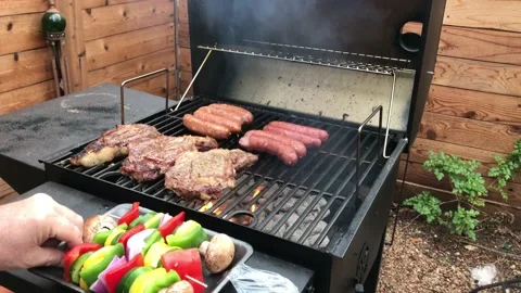 Back yard Texas BBQ grill cooking steak, chicken sausage and shish kabob Stock Footage