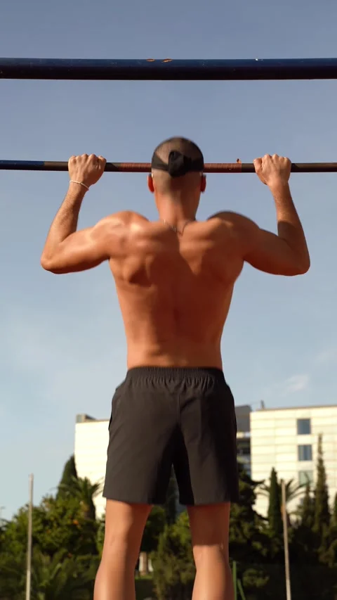 Back of a young boy performing barbell pull-ups in a sports club. Vertical .. Stock Footage 267894492