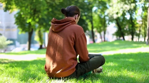 Back of young freelance man using modern laptop sitting in sunny green park 스톡 동영상 139201184