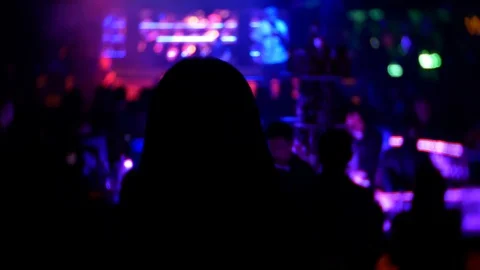 Back of young woman dancing in the crowd in the middle of the club Stock Footage 86535146