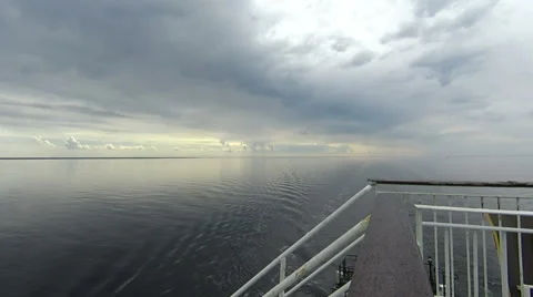 Backdrop of moody sky in the evening with still water on a boat deck Stock Footage 64272945
