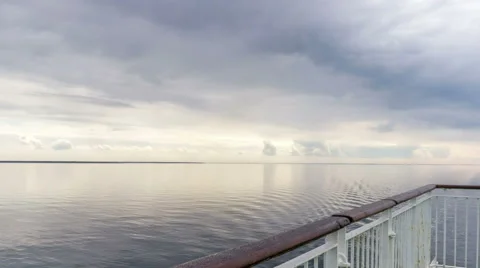 Backdrop of moody sky in the evening with still water on a boat deck Stock Footage 64275560