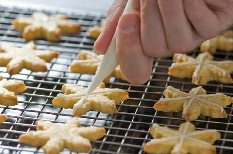 Backer decorates christmas cookies on the backing tray Stock Photos