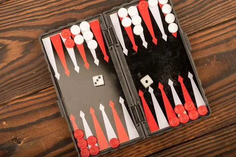 Backgammon board with chips and dice on a wooden table, close-up, selective f Stock Photos