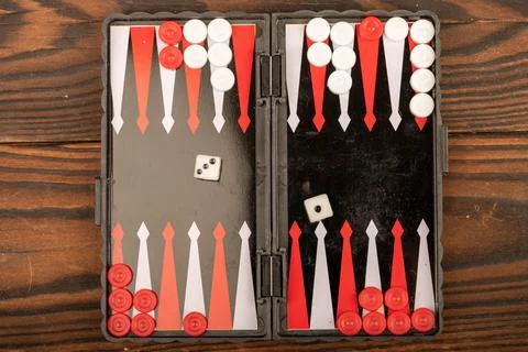 Backgammon board with chips and dice on a wooden table, close-up, selective f Stock Photos