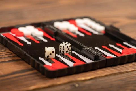 Backgammon board with chips and dice on a wooden table, close-up, selective f Stock Photos
