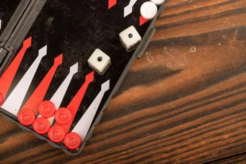 Backgammon board with chips and dice on a wooden table, close-up, selective f Stock Photos
