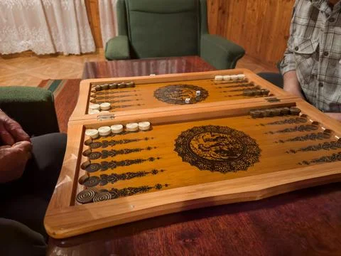 Backgammon board during intense game between two senior people Stock Photos
