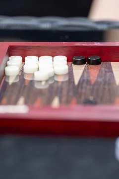 Backgammon Board Game Close-Up with White and Black Checkers on Wooden Red .. Stock Photos