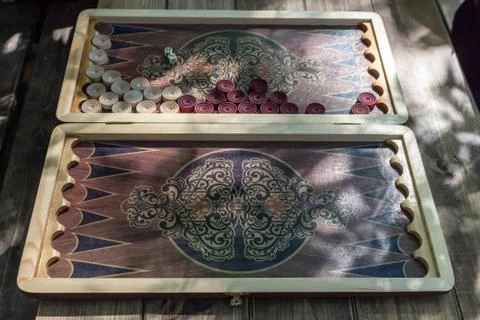 Backgammon board game for two players on a special board. Sun rays Stock Photos