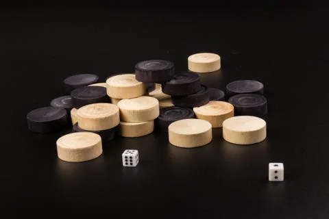 Backgammon. Board game. White cubes and chips on a blackboard.  Dice on backg Stock Photos