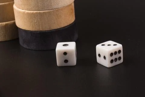 Backgammon. Board game. White cubes and chips on a blackboard.  Dice on backg Stock Photos