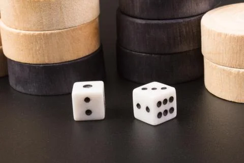 Backgammon. Board game. White cubes and chips on a blackboard.  Dice on backg Stock Photos