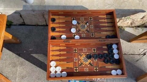 Backgammon game with wooden board and black and white pieces outdoors casti.. Stock Footage 330548319