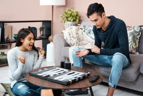 The backgammon queen of self quarantine. a young couple playing a game of chess Stock Photos