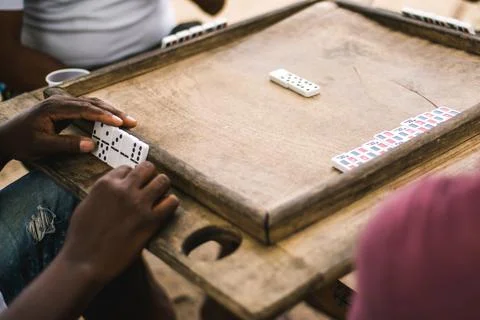 Backgammon table - board game. Dark-skinned people play backgammon Stock Photos