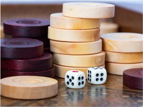Backgammon. White cubes and chips on a blackboard. Stock Photos