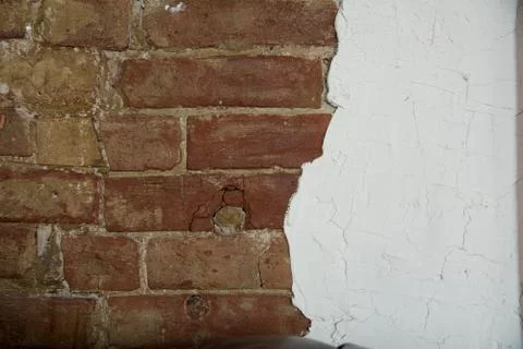 Background is an aged brick wall and white plaster 스톡 사진