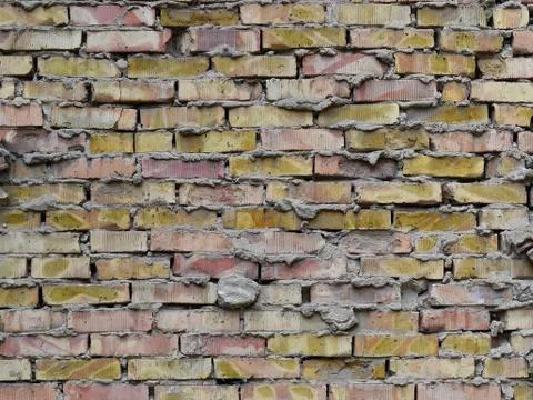 Background of aged rough brick wall of red and yellow bricks Stock Photos