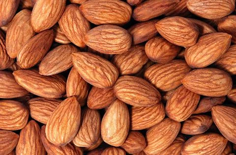 Background of almonds. Fried almonds. Scattered almond grains. Background for Stock Photos