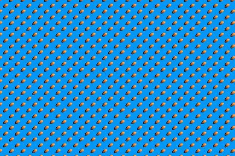 Background from almonds. Trendy sunny pattern of almonds on a bright blue bac Stock Photos