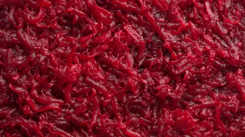 Background and texture of raw fresh grated red beetroot vegetable, rotates Stock Footage 186908837