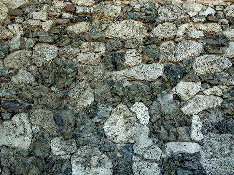 Background and texture. The wall is faced with gray natural stone of various  Stock Photos