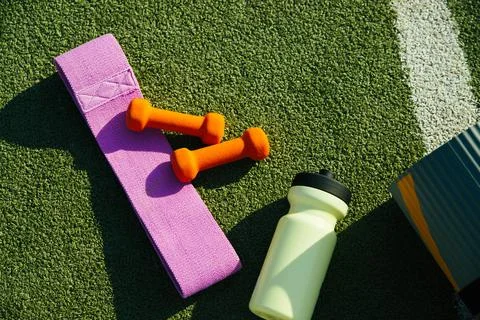 On the background of artificial grass there is a mat, a bottle, a fitness ela Foto stock