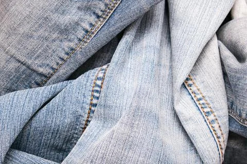 Background, backdrop of many folded old blue jeans denim Stock Photos