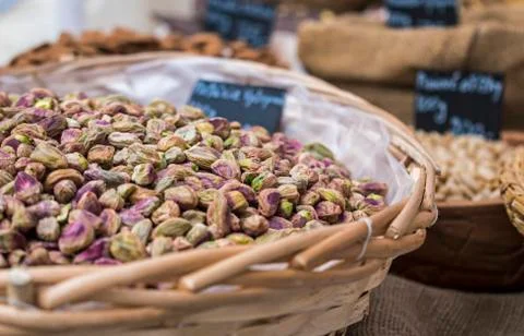 Background of basket of pistachios without shells on market, selective focus Stock Photos