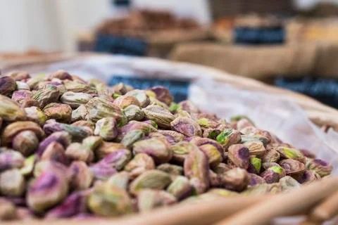 Background of basket of pistachios without shells on market, selective focus Stock Photos