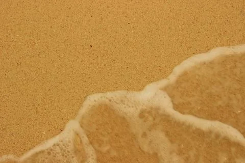 Background beach sand, and foam of the surf Stock Photos
