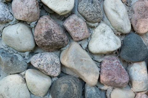 A background of beautiful multi-colored textured stones, fastened with cement 스톡 사진
